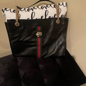Black Leather Gucci Tote Bag with Gold Chain Straps and attached wallet.